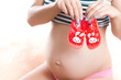 pregnant woman with baby shoes in the hands