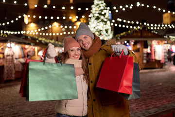 Wall Mural - happy couple at with shopping bags in winter