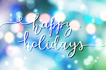 Wall Mural - happy holidays lettering, vector handwritten text on blurred background of garland