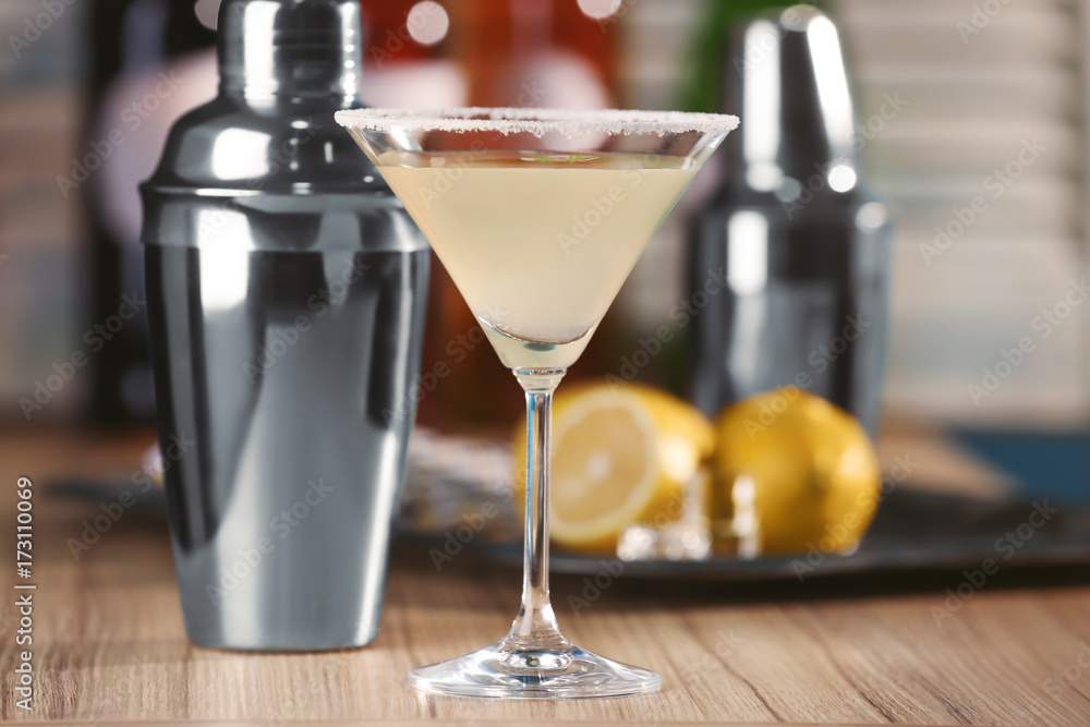 Glass with tasty lemon drop martini cocktail on table