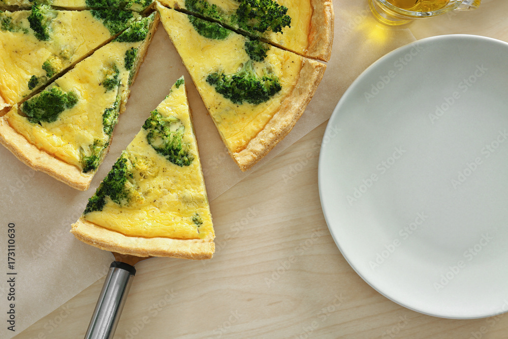 Tasty broccoli quiche on wooden table
