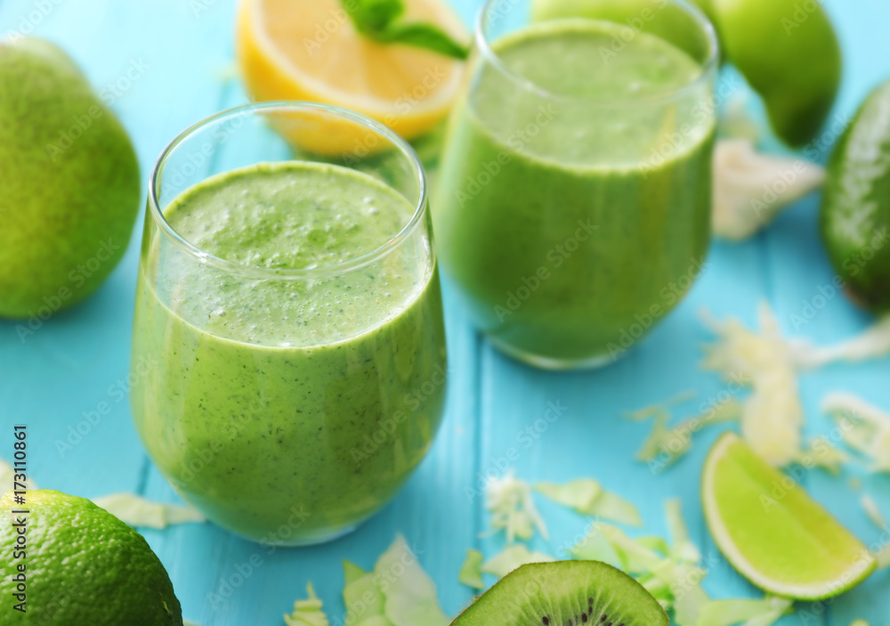 Healthy smoothie with kale in glasses on wooden table