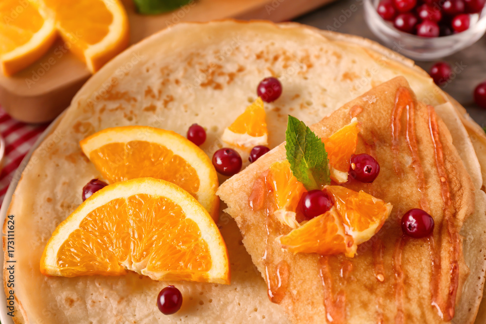 Delicious pancakes with orange and cranberry on plate, closeup