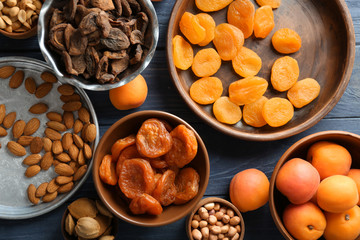 Wall Mural - Dried apricots and nuts in different dishes on wooden table