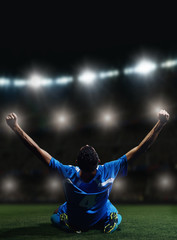 Wall Mural - soccer player in front of big modern stadium with flares and lights