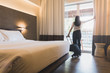 © bunditinay - Asian women are staying in a hotel room. Open the curtain in the room Along with carrying luggage.