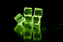 Green Ice Cubes On Black Background.