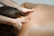 © javiindy - Young woman receiving a back massage in a spa center.