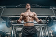 © antondotsenko - Handsome model young man training arms in gym