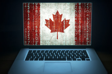 Canadian hacker. Laptop with binary computer code and Canada flag on the screen. Internet and network security.