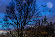 Fantasy Composition Of Birds Flying By The Moon Over A Church