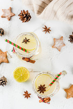 Fall And Winter Drinks. Christmas Holiday Beverage. Festive Snowball Cocktail With Lime Juice, Cinnamon, Liqueur, Sugar And Anise Stars. On White Table With Christmas Decoration, Copy Space Top View