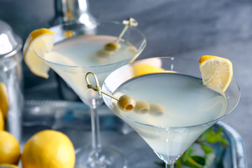 Canvas Print - Glasses of lemon drop martini with olives on blurred background, closeup