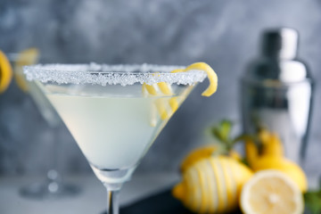 Canvas Print - Glass of lemon drop martini with zest on blurred background, closeup