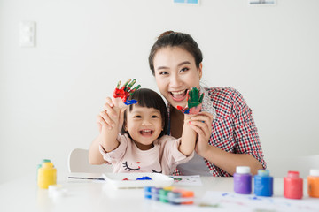 Wall Mural - A happy family is painting. Mom help her daughter drawing