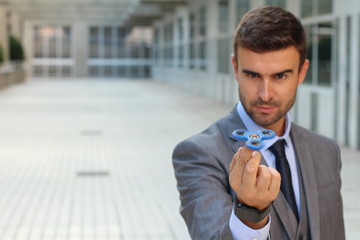 Cute businessman playing with a hand spinner