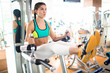 © pressmaster - Young gritty woman holding by handles of sport equipment while stretching her legs