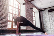 © undrey - Young sporty woman practicing yoga doing triangle pose, trikonasana, on mat