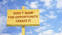 Don't Wait For Opportunity, Create It. Words On A Wooden Sign Against Time Lapse Clouds In The Blue Sky. 