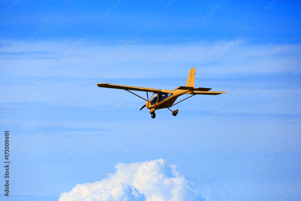 Samolot awionetka ultralekki w powietrzu na błękitnym niebie. - obrazy, fototapety, plakaty 