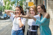 © Bojan - Three happy teenage girls looking something in front of them and taking a photograph on mobile phone, outdoors.
