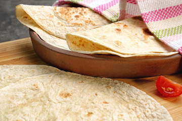 Sticker - Wooden board with delicious tortillas on table, closeup