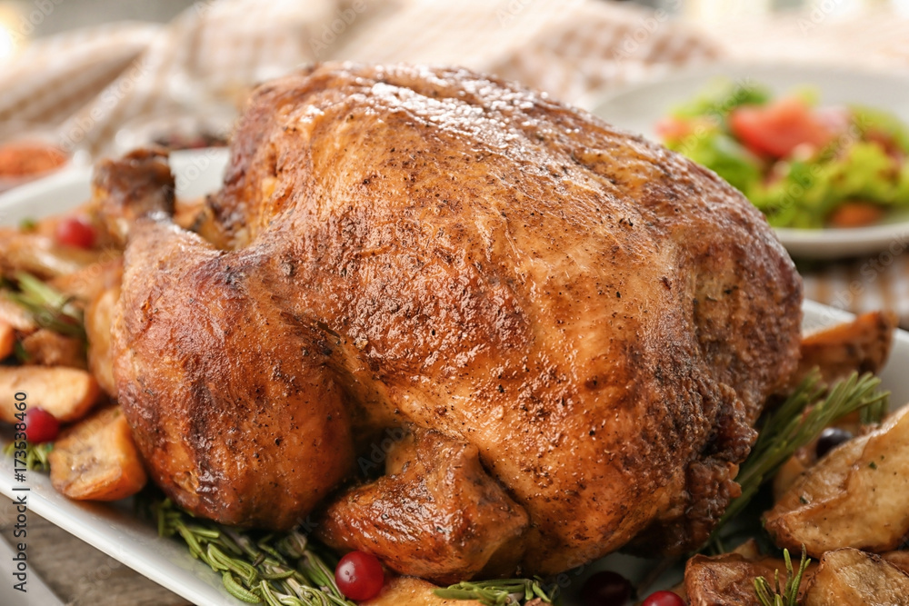 Tasty roasted turkey with potatoes on plate