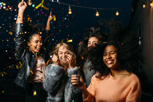 Group Of Female Friends Enjoying Night Party, Throwing Confetti