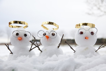 Three cute snowman angles with golden halos