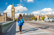 © Maridav - London city urban lifestyle tourist woman walking. Businesswoman commuting going to work on Westminster bridge street early morning. Europe travel destination, England, Great Britain, UK.
