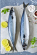 Fresh, raw mackerel with lemon and spices on a concrete background