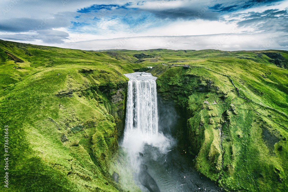 Iceland waterfall Skogafoss in Icelandic nature landscape. Famous tourist attractions and landmarks destination in Icelandic nature landscape on South Iceland. Aerial drone view of top waterfall. - obrazy, fototapety, plakaty 