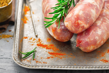 Poster - Close up raw sausages for grilling on tray with rosemary