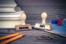 Original And Copy Concept. Rubber Stamp On Desk In The Office. Business And Work Background.