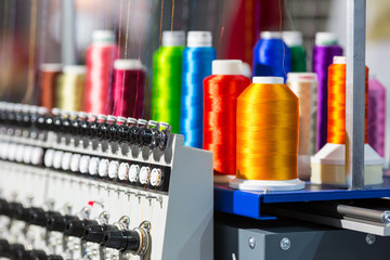 Spools of color threads closeup, spinning machine