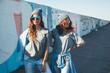 © Alena Ozerova - Models wearing plain tshirt and sunglasses posing over street wall