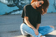 © Alena Ozerova - Model wearing plain tshirt and sunglasses posing over street wall