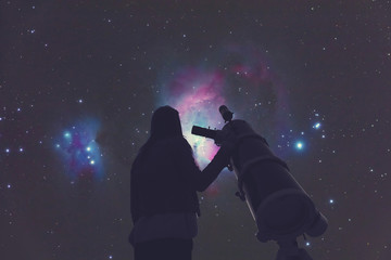 Wall Mural - girl looking at the stars through a telescope.