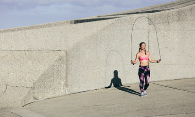 Wall Mural - Fit young woman skipping rope