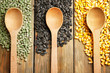 Composition with spoons and different grains on wooden background
