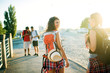 © dusanpetkovic1 - Rear view of two gorgeous girls walking on the street with backpacks and hat.