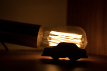 A toy car light  from behind by a fancy light bulb