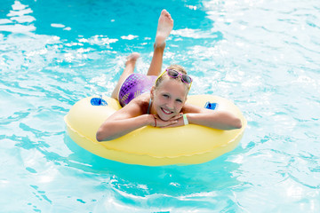 A young girl in the pool on an inflatable lap