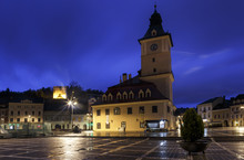 The Council Square During Rain In Brasov, Romania. View With Famous Buildings In Evening .
