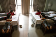 © Lawrence del Mundo/Stocksy - Three young kids busy watching TV inside their hotel room