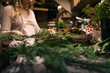 © Robert Zaleski/Stocksy - Woman's hands making a holiday wreath in work shop.