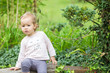 © Deymos.HR - One and a half year old toddler girl sitting on the wooden bench and holding an ripe orange pumpkin