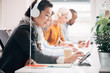 © Aila Images/Stocksy - Group of young professional business people students working on technology listening to music studying