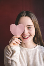 Portrait Of Young Woman Holding Cut Pink Heart