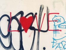 The Word Love And A Heart Painted On A Wall.